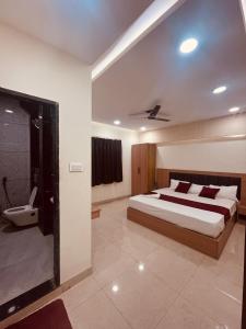 ウッジャインにあるHotel Siddhi Shreeの大きなベッドとバスルームのある寝室