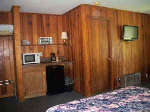 a room with a bed and a microwave and a tv at Two Rivers Lodge in Bryson City