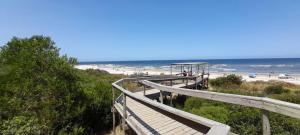 a boardwalk leading to a beach with people on it at Casa San Luis Salerno in Ciudad de la Costa