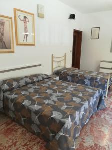 Un dormitorio con una cama grande en una habitación. en LOCRI SUITE più CAMERE, en Locri