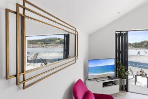 a living room with a large window and a tv at Teign View, Grand Banks in Teignmouth