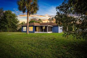 una casa con una palmera en un patio en Families and large groups, with TVs in every room, en Palm Bay
