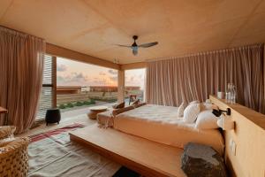 a bedroom with a large bed and a large window at Kymaia Hotel in Tlachicón