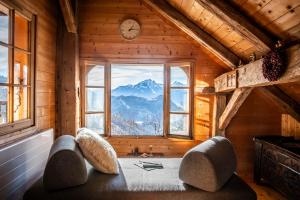 Habitación con ventana grande en una cabaña de madera en Slow Chalet de l'Ourse - Charming old chalet stunning view sauna pets ok, en Serraval