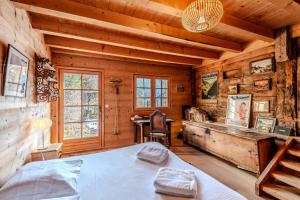 Un dormitorio con una cama en una cabaña de troncos en Slow Chalet de l'Ourse - Charming old chalet stunning view sauna pets ok, en Serraval