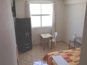 a bedroom with a bed and a table and a window at Hospedaje el Telar in Nazca