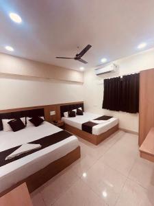 ウッジャインにあるHotel Siddhi Shreeのベッド2台と天井ファン付きの寝室