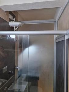 a shower with a glass door in a bathroom at Apartamento Studio in Diamantina