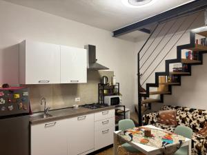 a kitchen with white cabinets and a staircase at Friendly Africa Room Como Center in Como +5 photos