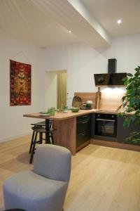 a kitchen with a table and a chair in a room at Dijon Hypercentre - Loge Des Ducs in Dijon
