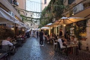 a group of people sitting at tables in an alley at Urban Oasis near Termini, Free Parking&Balcony, int10 in Rome