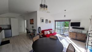 a living room with a table and a red couch at Bidwills Gem in Greytown