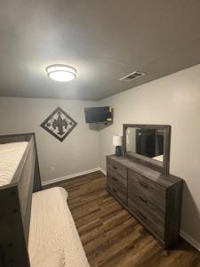 una camera da letto con TV e comò con specchio di Perkins Cove a Baton Rouge