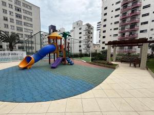 a playground with a slide in a city at Ocian: 2 quartos, suíte, piscina e perto da praia in Samaritá
