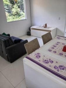 ein Wohnzimmer mit einem Tisch, Stühlen und einem Waschbecken in der Unterkunft Casa de Campo in Governador Celso Ramos