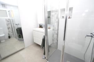a white bathroom with a shower and a sink at Marvelous apartment in Playa del Ingles in Maspalomas