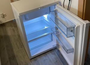 an empty refrigerator with its door open in a kitchen at Zimmer in Hafennähe in Dierhagen