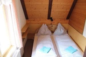 two beds in a small room with a window at Apartmány Černá Říčka in Desná