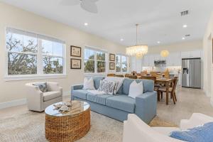 Una sala de estar con un sofá azul y un comedor. en Stunning - Close to the Beach, Heated Pool, en Fort Myers Beach