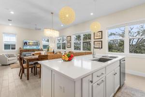 Una cocina y sala de estar con gabinetes blancos y una mesa. en Stunning - Close to the Beach, Heated Pool, en Fort Myers Beach 19 fotos más