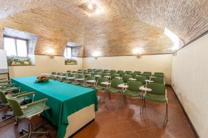 sala konferencyjna z zielonym stołem i krzesłami w obiekcie Hotel&Ristorante Miramonti Palazzo Storico w mieście Rieti