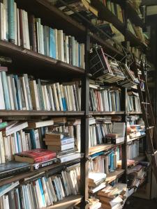 a stack of books on shelves in a library at La Gallina Felice B&B in Meta