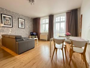 una sala de estar con un sofá y una mesa en UNO Apartaments, en Katowice