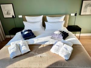 ein Bett mit Handtüchern und Kissen darüber in der Unterkunft FIRST im FIRST Sellin, Penthouse Meer & Meer mit phänomenalem Ostseeblick in Ostseebad Sellin