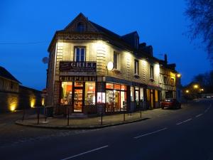 a building on the corner of a street at night at La Bonne Famille in Jumièges