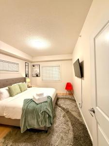 una camera da letto con un grande letto e una sedia rossa di 2bedroom luxury Condo a Edmonton
