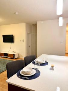 un tavolo con piatti e bicchieri sopra in una stanza di 2bedroom luxury Condo a Edmonton