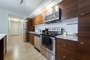una cucina con elettrodomestici in acciaio inossidabile e mobili in legno di 2bedroom luxury Condo a Edmonton