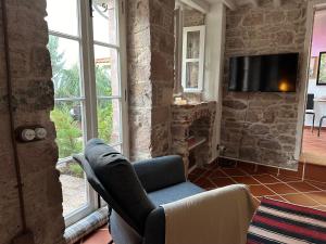 a living room with a chair and a television at Papalina in Ayvalık