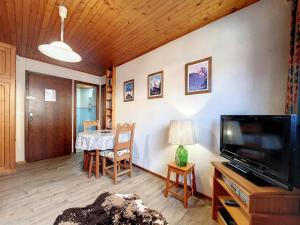 a living room with a table and a television at Studio cosy à La Clusaz - 2 pers, animaux admis - FR-1-818-59 in La Clusaz +2 photos