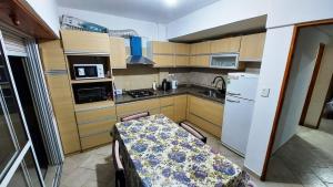 a small kitchen with a table and a refrigerator at Departamento 11 - Av 1 - Grupo DEL SALVADOR in Las Toninas