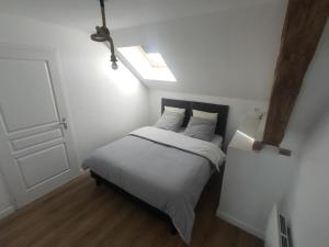 Un dormitorio con una cama blanca con tragaluz. en Gîte Rouge paisible à la ferme, animaux acceptés, wifi inclus - FR-1-489-559, en Saint-Bonnet-de-Four