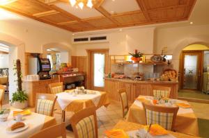 une salle à manger avec deux tables et une cuisine dans l'établissement Hotel Stamserhof, à Andrian