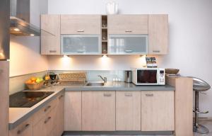 a kitchen with wooden cabinets and a microwave at Abra 2 Apartments in Krakow