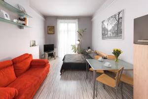 sala de estar con sofá rojo y mesa en Abra 2 Apartments, en Cracovia