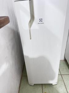 a white refrigerator freezer sitting in a kitchen at Pousada Brisa do Mar in Tramandaí