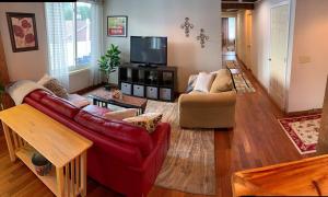 a living room with a red couch and a tv at Black Jacks Downtown Loft in West Jefferson