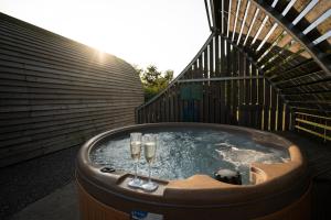 einen Whirlpool mit zwei Champagnergläsern in der Unterkunft Sedgewell Barn by Wigwam Holidays in Northallerton