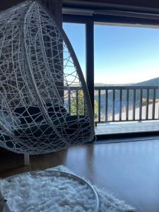 a hanging hammock in a room with a window at Sweet Quintanilha in Quintanilha +65 photos