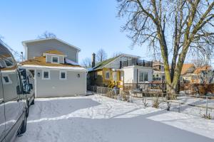 埃文斯顿2 Mi to Northwestern Updated Home with Game Room!的雪中停放汽车的房子