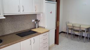a kitchen with white cabinets and a table with chairs at Casa Noa in Serrapio
