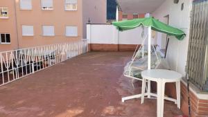 a table and a green umbrella on a balcony at Casa Noa in Serrapio