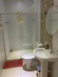 a bathroom with a toilet and a sink at Chácara Lara Bela in Praia do Saco +18 photos