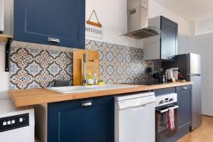 a kitchen with blue cabinets and a white sink at Champigny - Spacieux logement entre Paris & Disney in Champigny-sur-Marne