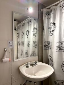 a bathroom with a sink and a mirror at Hotel Miami in San Miguel de Tucumán