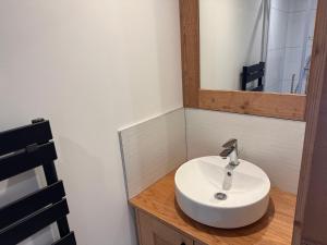 une salle de bain avec un lavabo blanc et un miroir dans l'établissement Appartement cozy 3P à 5m du front de neige avec parking et terrasse - FR-1-464-236, à Pralognan-la-Vanoise